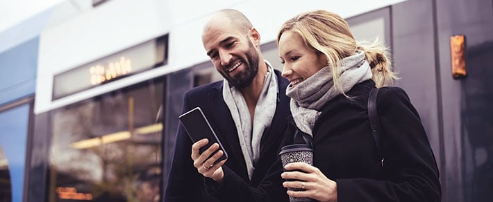 Mann und Frau schauen auf ein Smartphone