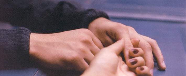 Mann und Frau halten Händchen als Symbol für Trennung trotz Liebe